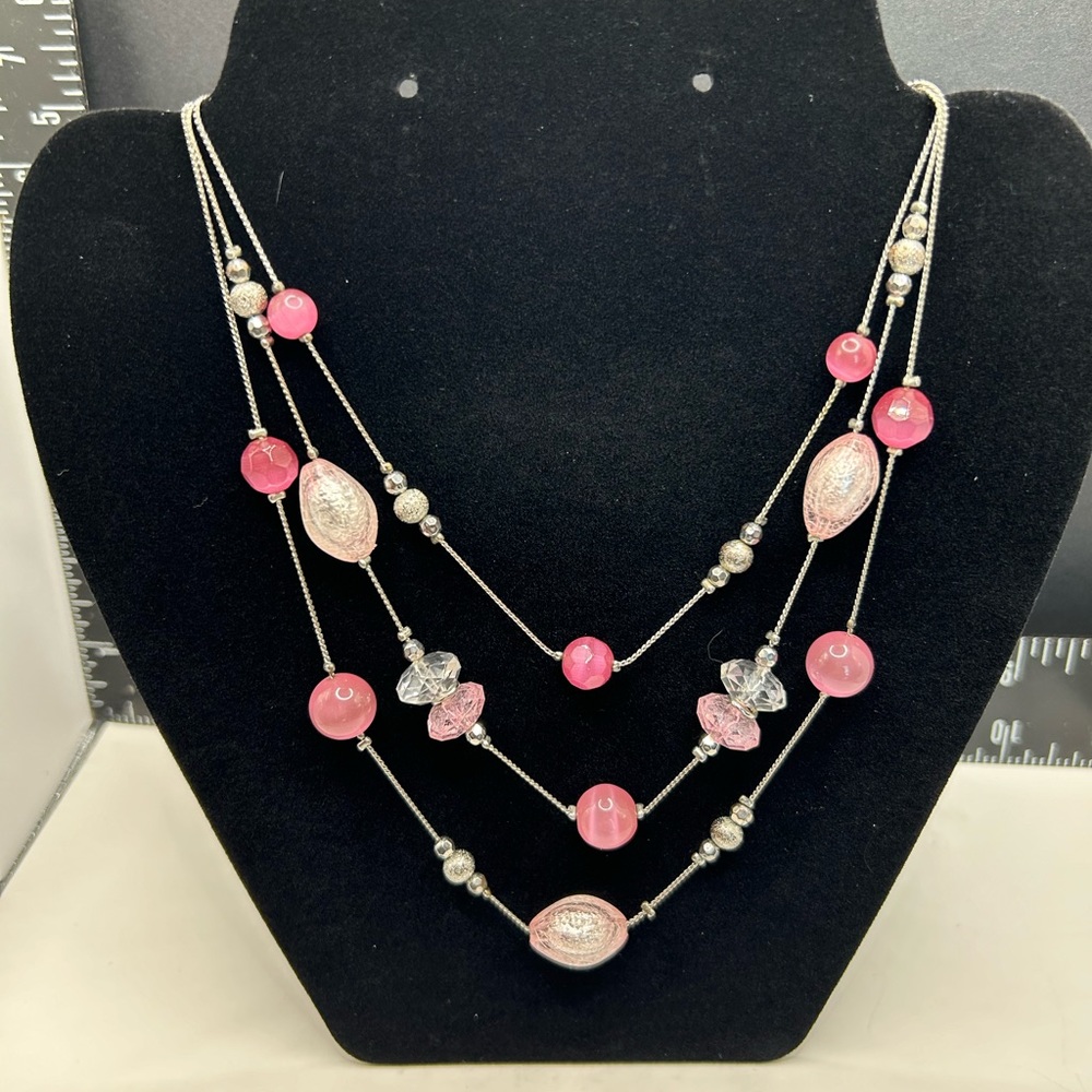 Three strands of pink cat eyeglass beads spaced by faux spun glass beads.